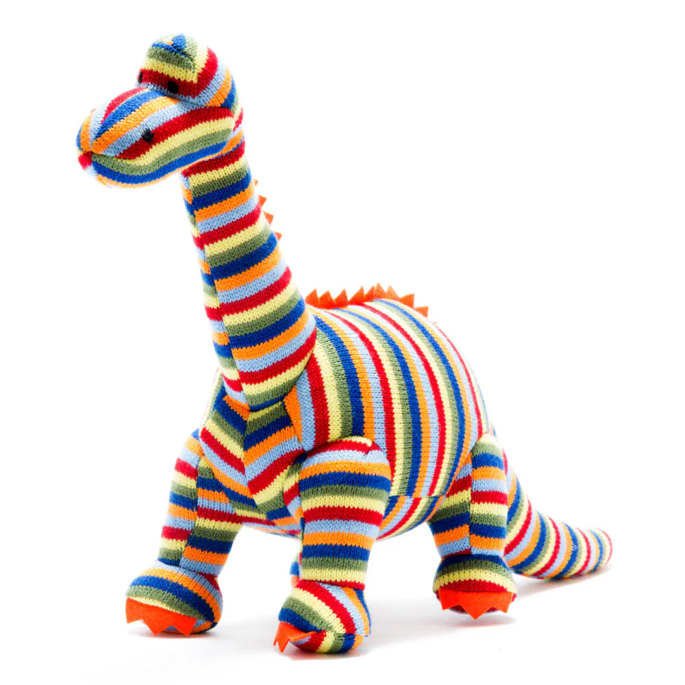 Best Years colourful knitted plush dinosaur toy with horizontal stripes in red, orange, yellow, green, blue, and white, standing on a white background.