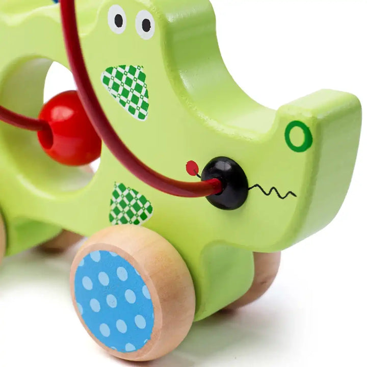 Bigjigs Toys children's push along green crocodile with colourful beads on a white background