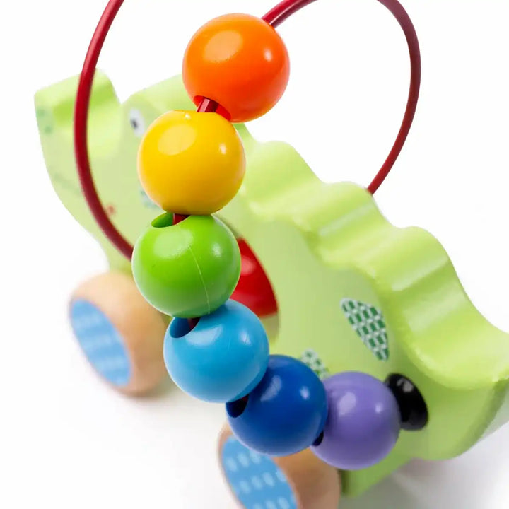 Bigjigs Toys children's push along green crocodile with colourful beads on a white background