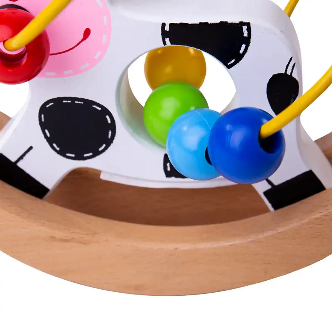 Bigjigs Toys wooden rocking cow bead frame with colourful beads on a white background