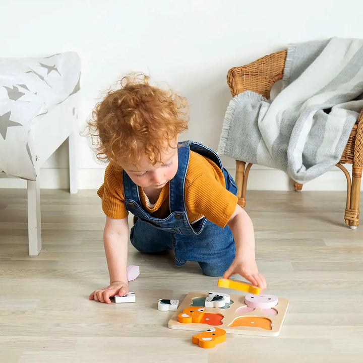 Child playing with a Bigjigs Toys woodland counting puzzle on the floor