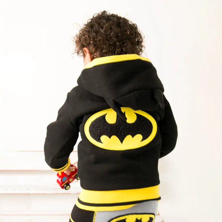 Child wearing a Blade and Rose black hoodie with a yellow Batman logo on a white background