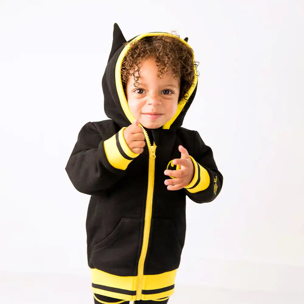 Child wearing a black and yellow Blade and Rose Batman themed hoodie with bat ears on a white background