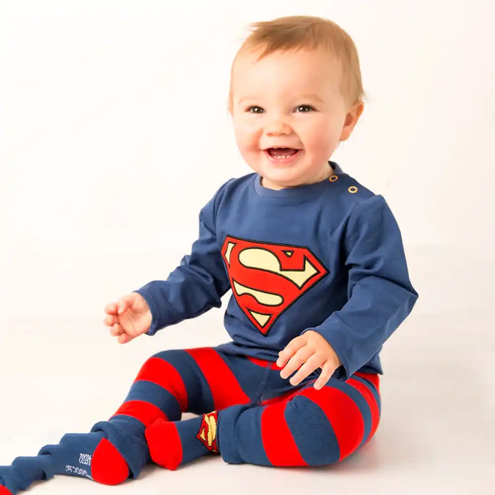 Baby wearing a Blade and Rose Superman outfit with a blue shirt and red striped pants on a white background