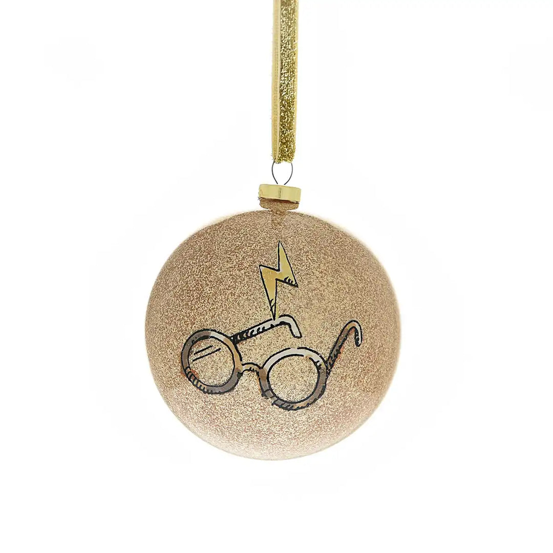 Round gold ornament with Harry Potter-themed design of glasses and a lightening bolt on a white background