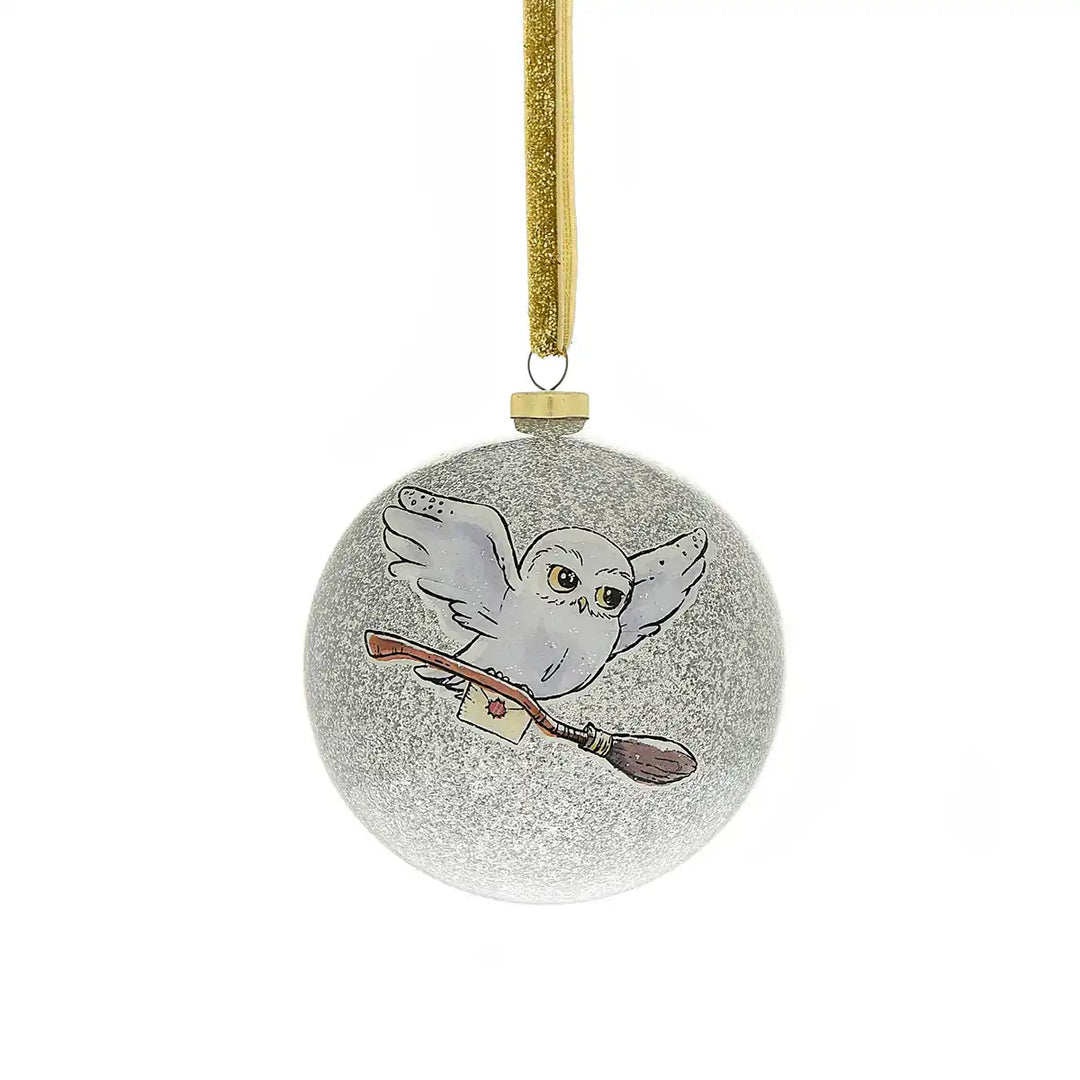 Harry Potter themed decorative bauble ornament with an owl and broomstick on a glittery ball, hanging from a gold ribbon.