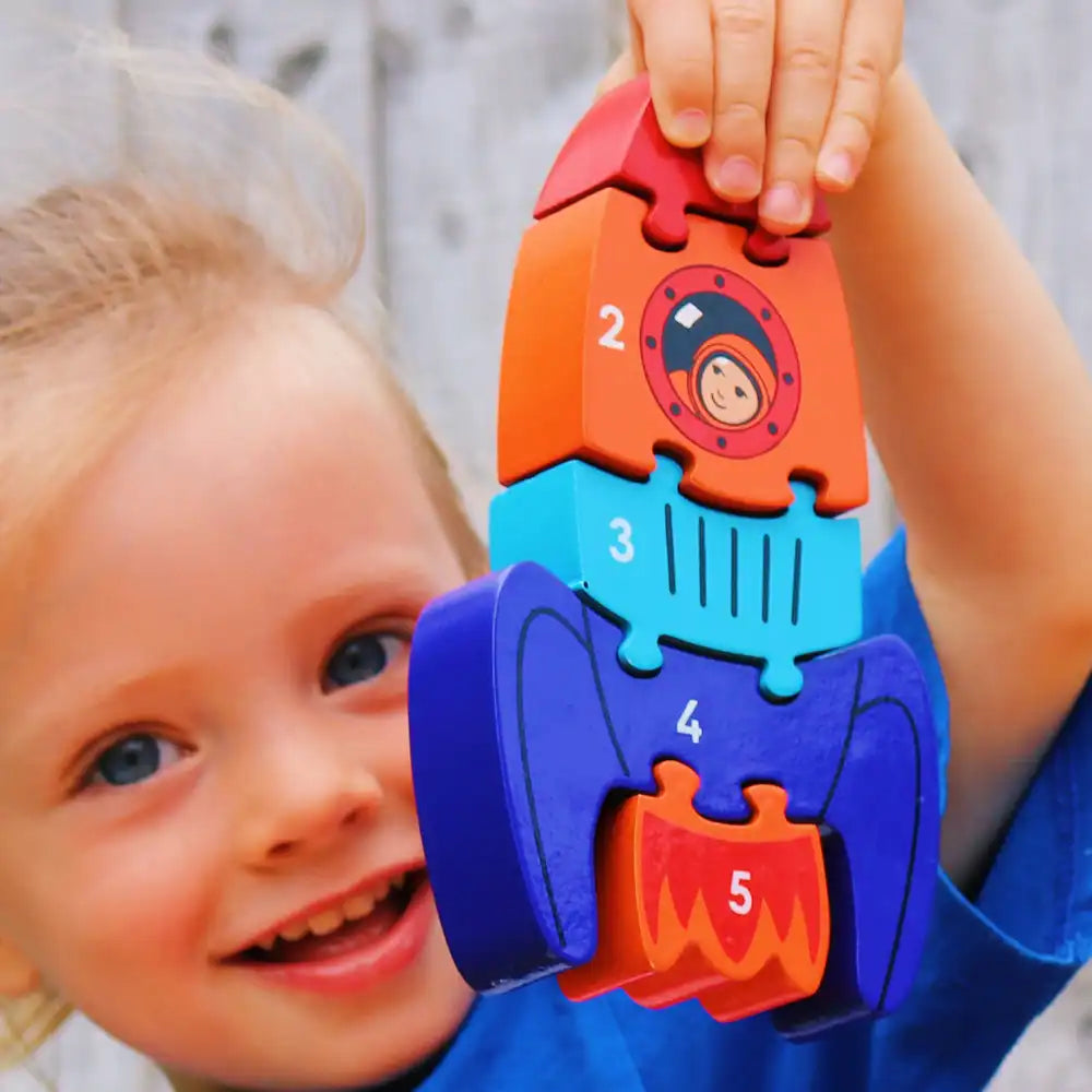 Child holding a colourful Lanka Kade rocket-shaped puzzle toy