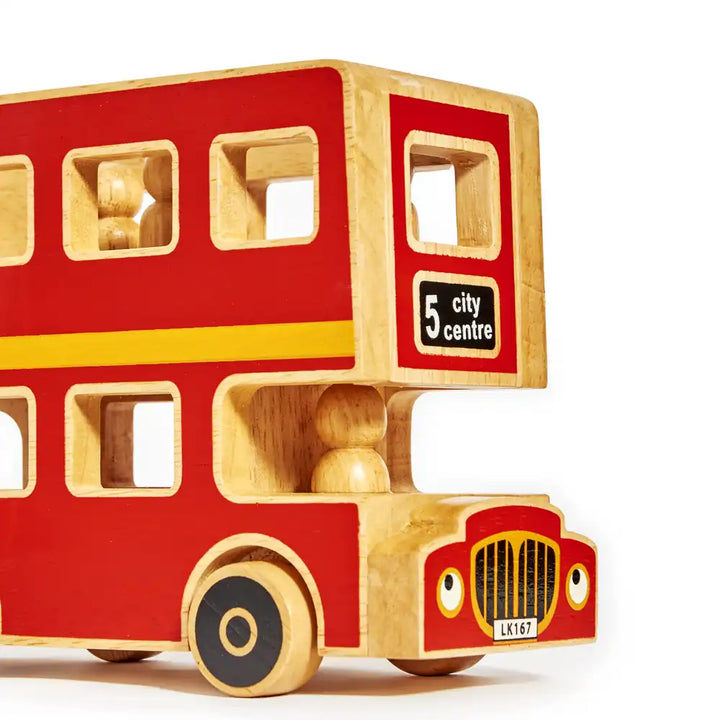 A Lanka Kade wooden double-decker toy bus in red and natural wood, featuring a black and white '5 city centre' sign on the side and a front grille with cartoon eyes.