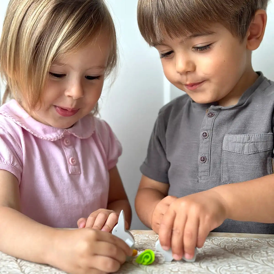 Children playing with Mentari dolls house rabbit hutch wooden pet set