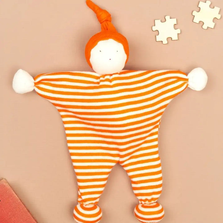 Under the Nile organic orange and white striped baby buddy and hat on a brown background