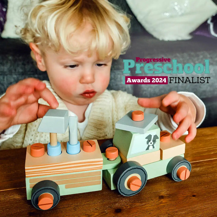Child playing with an Orange Tree Toys buildable tractor on a wooden surface, with 'Progressive Preschool Awards 2024 Finalist' text overlay.
